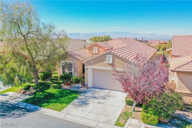 view of front of property featuring a mountain view, a garage, and a front lawn