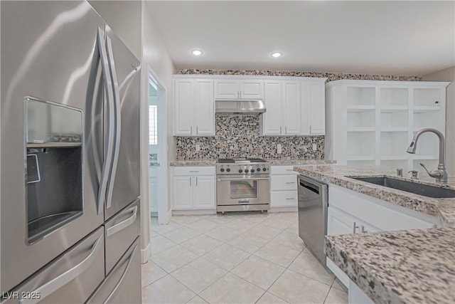 kitchen featuring light stone countertops, white cabinetry, appliances with stainless steel finishes, and sink