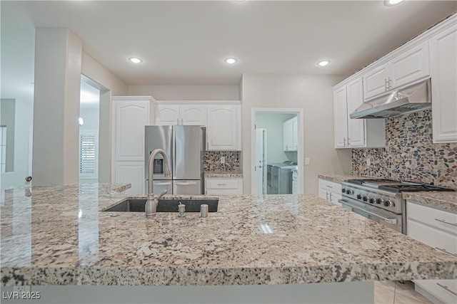 kitchen with white cabinetry, sink, decorative backsplash, stainless steel appliances, and light stone countertops