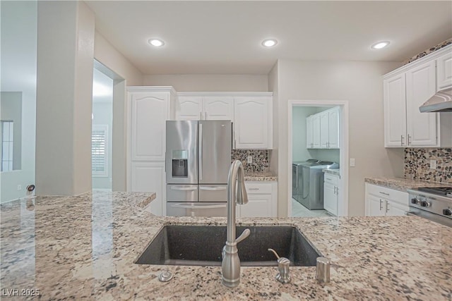 kitchen with white cabinetry, light stone counters, tasteful backsplash, washer and dryer, and stainless steel fridge with ice dispenser