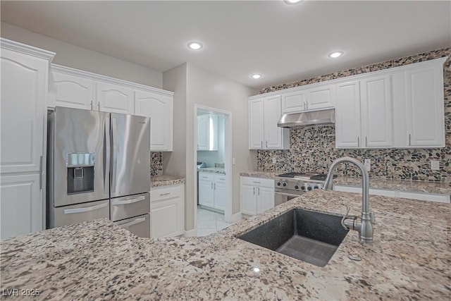 kitchen featuring sink, white cabinetry, stainless steel appliances, tasteful backsplash, and light stone counters