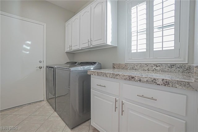 laundry room with cabinets, plenty of natural light, light tile patterned floors, and washer and clothes dryer