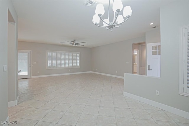 spare room featuring ceiling fan with notable chandelier and light tile patterned floors