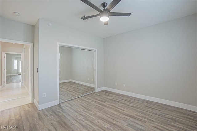 unfurnished bedroom with light hardwood / wood-style floors, ceiling fan, and a closet