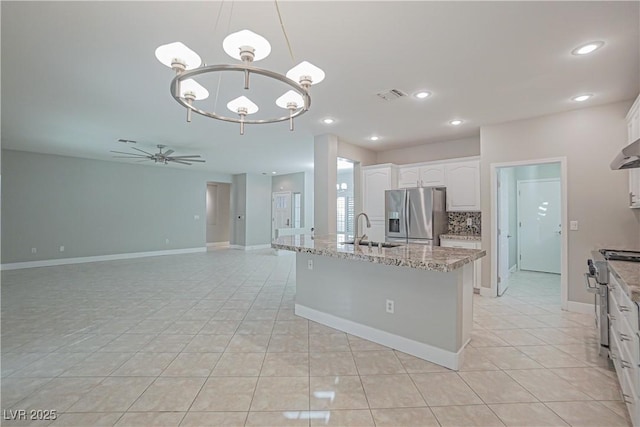 kitchen featuring tasteful backsplash, an island with sink, pendant lighting, stainless steel appliances, and white cabinets