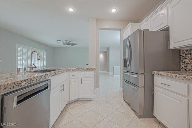 kitchen with sink, light tile patterned floors, ceiling fan, white cabinetry, and stainless steel appliances