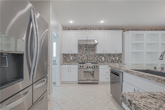 kitchen featuring light tile patterned floors, sink, appliances with stainless steel finishes, white cabinetry, and light stone countertops