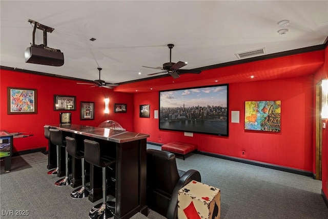 home theater featuring ceiling fan, carpet flooring, and bar area