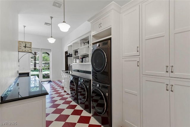 washroom featuring french doors, stacked washer / drying machine, and sink