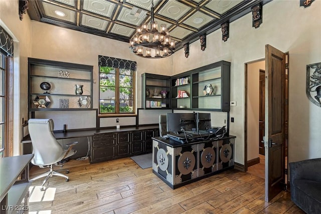 office space with built in desk, an inviting chandelier, and light hardwood / wood-style flooring