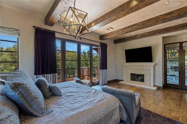 bedroom featuring hardwood / wood-style flooring, access to exterior, a chandelier, and french doors