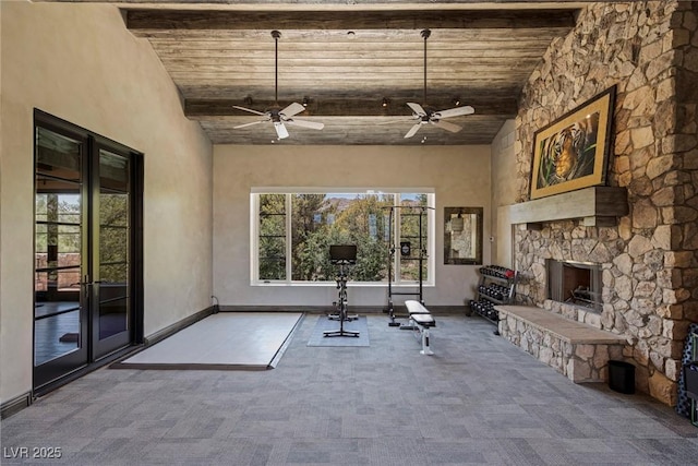 exercise area featuring high vaulted ceiling, carpet flooring, an outdoor stone fireplace, ceiling fan, and french doors