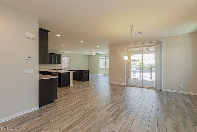 kitchen with a kitchen island with sink, sink, hanging light fixtures, and ceiling fan