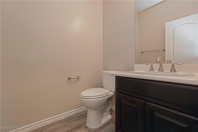 bathroom with hardwood / wood-style flooring, vanity, and toilet