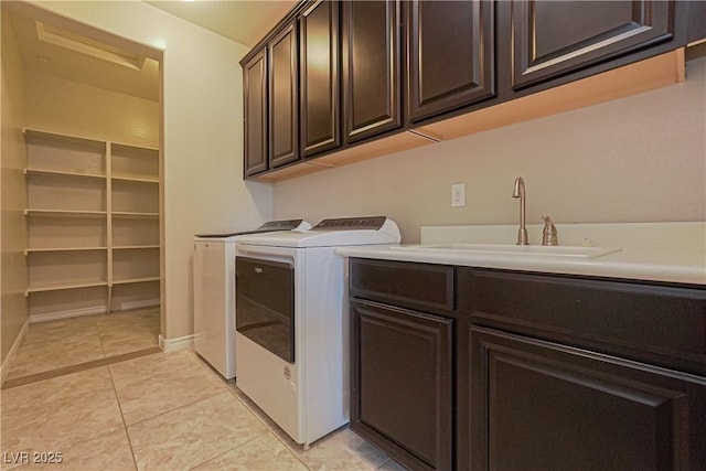 laundry area featuring cabinets, separate washer and dryer, sink, and light tile patterned floors