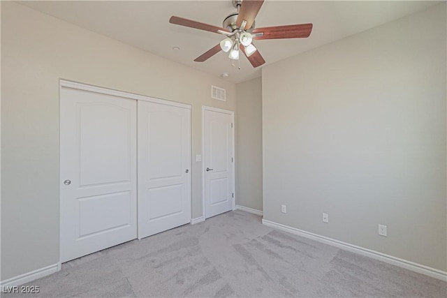 unfurnished bedroom with light carpet, a closet, and ceiling fan