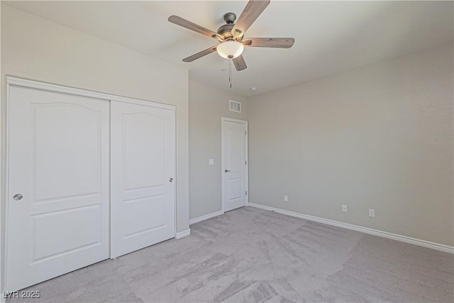 unfurnished bedroom with light colored carpet, a closet, and ceiling fan