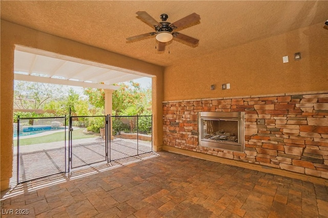 interior space featuring ceiling fan and an outdoor stone fireplace