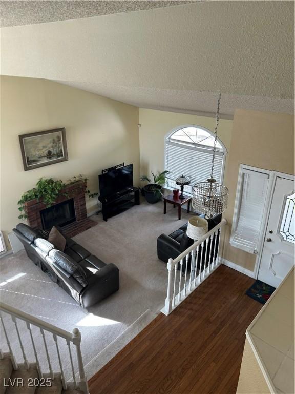 living room featuring a textured ceiling, vaulted ceiling, and dark hardwood / wood-style floors