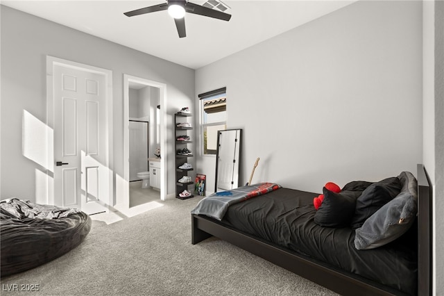 bedroom featuring light carpet, ceiling fan, and ensuite bathroom