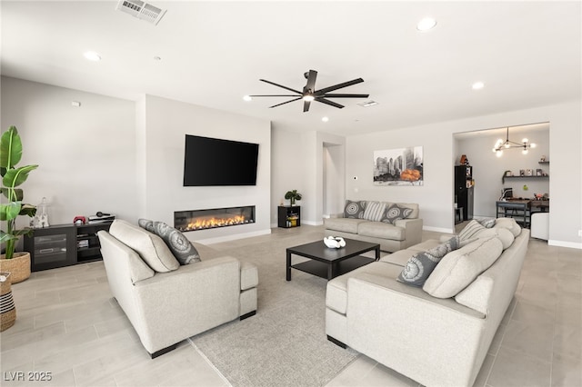 living room featuring ceiling fan with notable chandelier