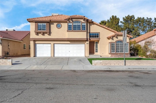 mediterranean / spanish home featuring a garage, concrete driveway, a tile roof, and stucco siding