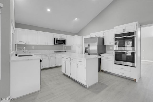 kitchen featuring stainless steel appliances, a center island, and white cabinetry