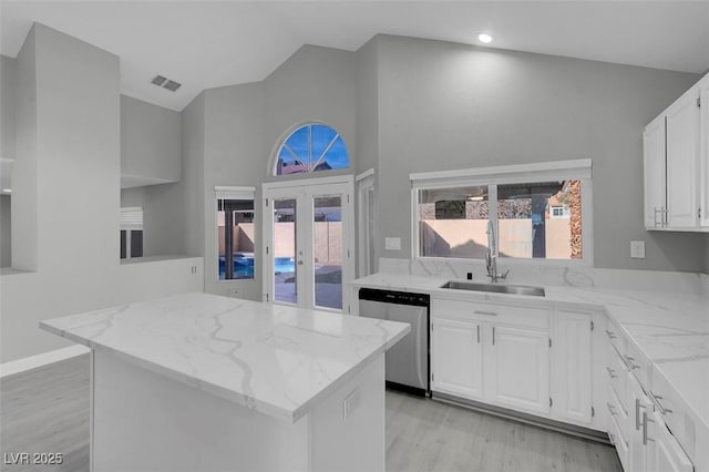 kitchen with light stone counters, visible vents, dishwasher, and a sink