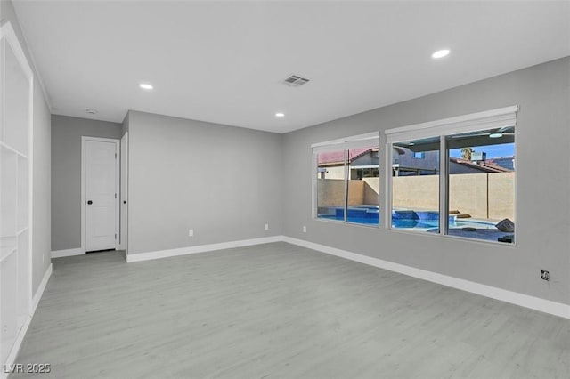 spare room featuring visible vents, baseboards, wood finished floors, and recessed lighting