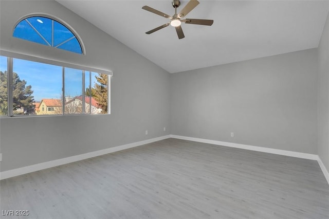 spare room with a ceiling fan, lofted ceiling, baseboards, and wood finished floors