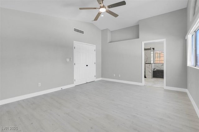 unfurnished bedroom featuring lofted ceiling, baseboards, visible vents, and wood finished floors