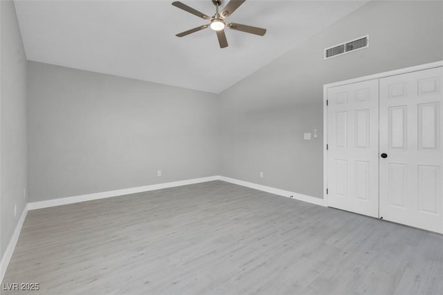 unfurnished bedroom featuring baseboards, visible vents, wood finished floors, vaulted ceiling, and a closet