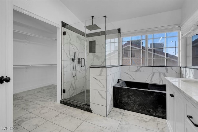 bathroom with vanity, marble finish floor, a spacious closet, a marble finish shower, and a bath