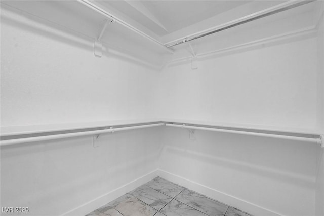 spacious closet featuring marble finish floor