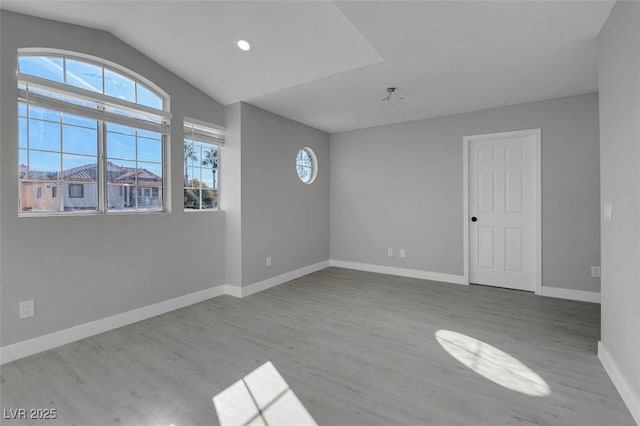 unfurnished room featuring lofted ceiling, baseboards, wood finished floors, and recessed lighting