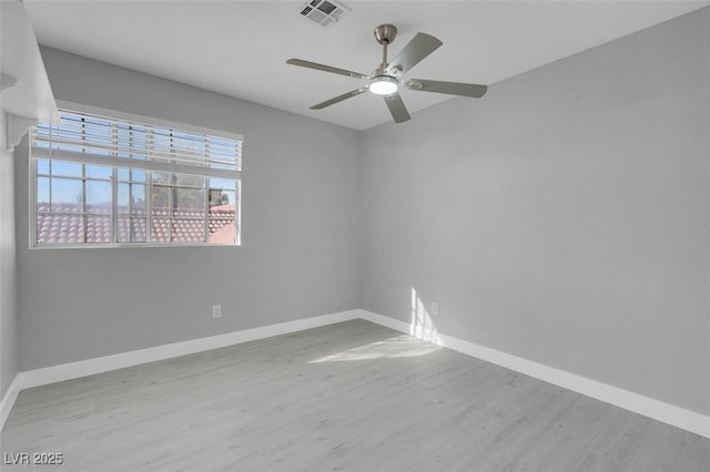 unfurnished room with ceiling fan, wood finished floors, visible vents, and baseboards