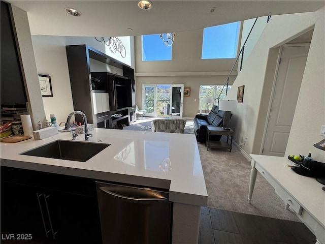 kitchen with stainless steel dishwasher, kitchen peninsula, and sink