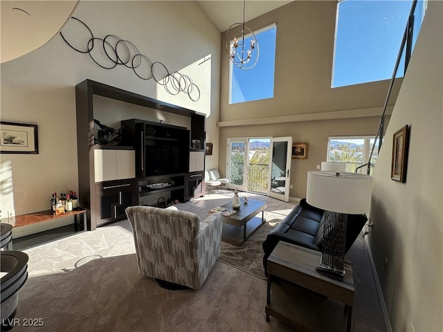 carpeted living room featuring an inviting chandelier and high vaulted ceiling