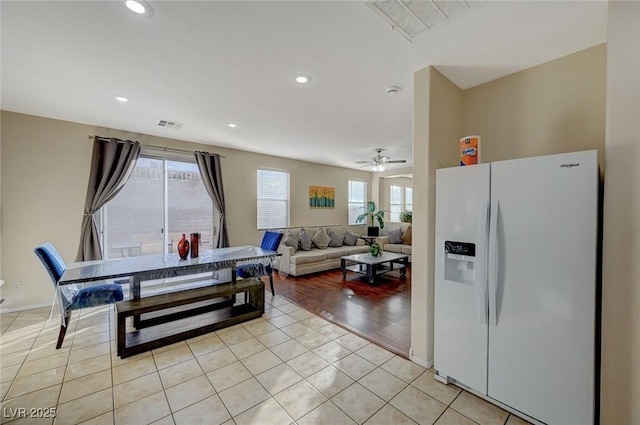 kitchen featuring light tile patterned flooring, white refrigerator with ice dispenser, a healthy amount of sunlight, and ceiling fan