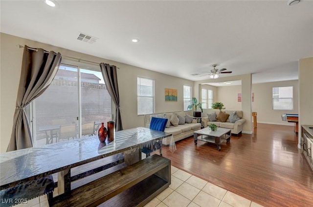 tiled living room with ceiling fan and a wealth of natural light