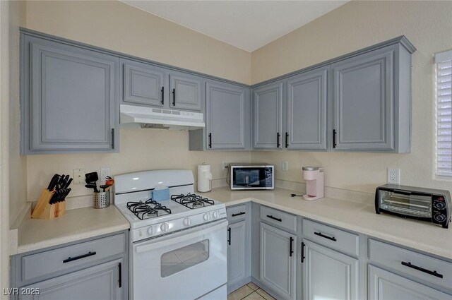 kitchen with light tile patterned flooring and white gas range