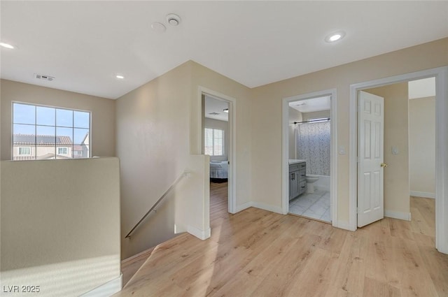 hall with plenty of natural light and light wood-type flooring