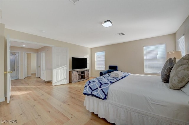 bedroom with multiple windows and light hardwood / wood-style flooring