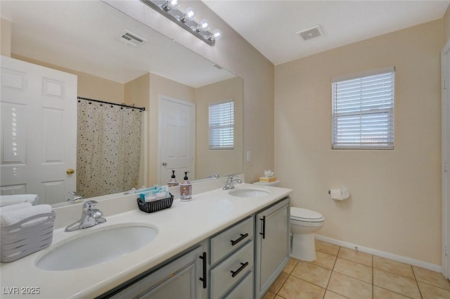 bathroom with tile patterned floors, toilet, curtained shower, and vanity