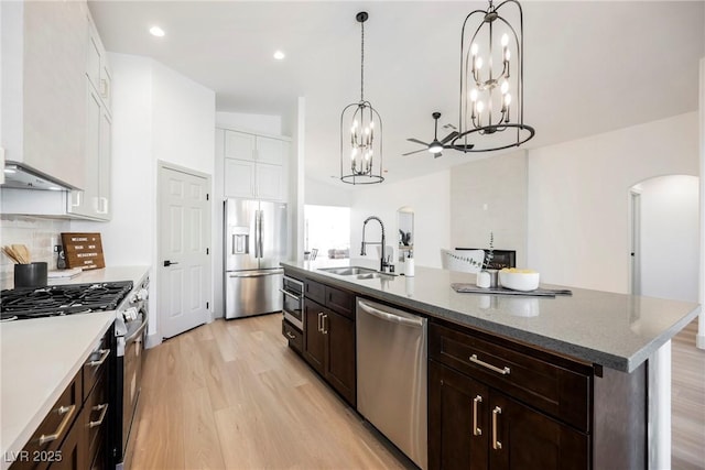 kitchen featuring decorative light fixtures, white cabinetry, sink, a kitchen island with sink, and stainless steel appliances