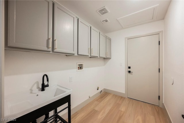 washroom with sink, gas dryer hookup, cabinets, light hardwood / wood-style flooring, and hookup for a washing machine