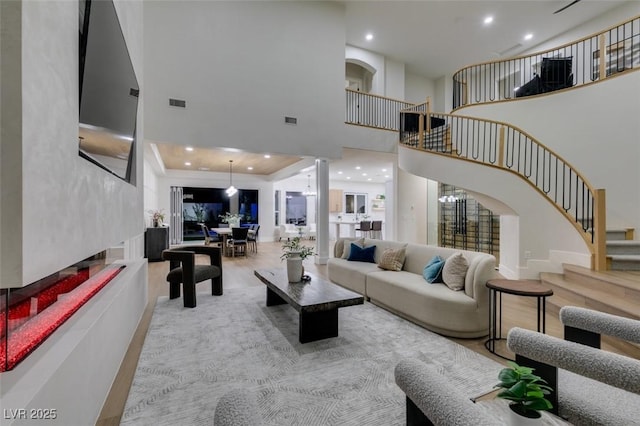 living room with a towering ceiling and light hardwood / wood-style floors