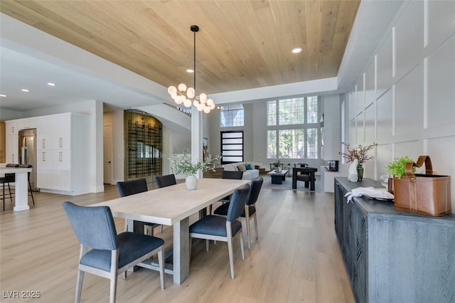 dining room featuring an inviting chandelier, light hardwood / wood-style flooring, and wooden ceiling