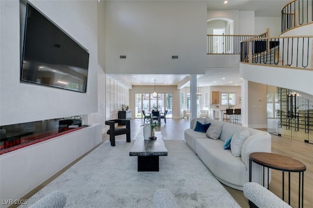 living room with light hardwood / wood-style floors and a high ceiling