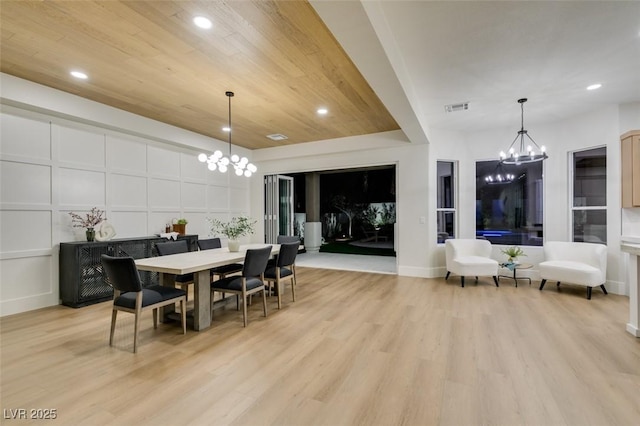 dining area featuring an inviting chandelier, wood ceiling, and light hardwood / wood-style floors